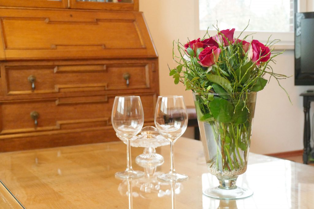 Ferienwohnungen-Hofmann - Tisch mit Blumen, Kerzen und Gläsern mit Wein, Erdgeschoss, Wohlfühlen in Ostfriesland, Friesland, Urlaub auf dem Land, Urlaub in Friesland,